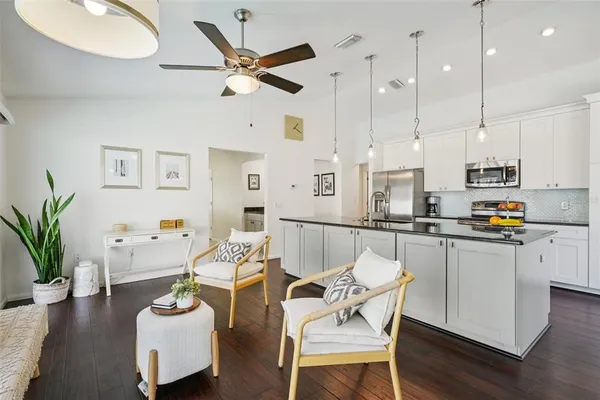 a kitchen with stainless steel appliances granite countertop a sink a stove and a wooden floors