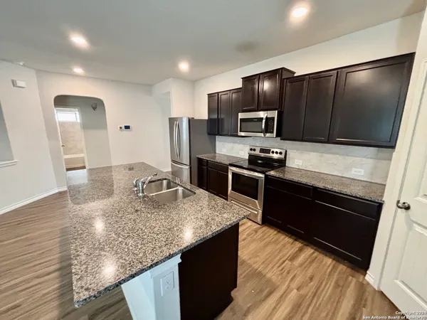 a kitchen with stainless steel appliances kitchen island granite countertop a refrigerator stove microwave and sink