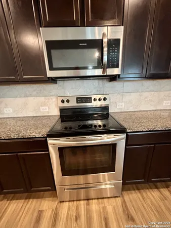 a kitchen with granite countertop a stove and a microwave