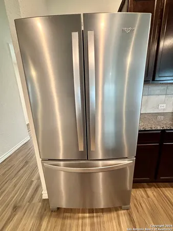 a view of a refrigerator in kitchen and wooden floor