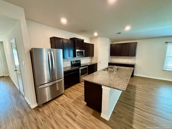a kitchen with stainless steel appliances granite countertop a refrigerator microwave and sink
