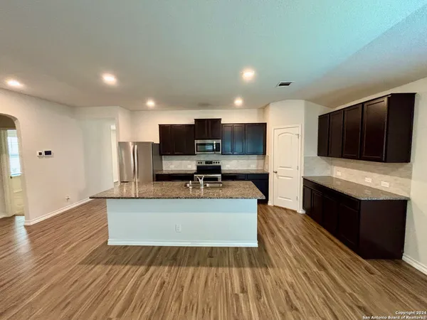 a view of kitchen with sink microwave and refrigerator