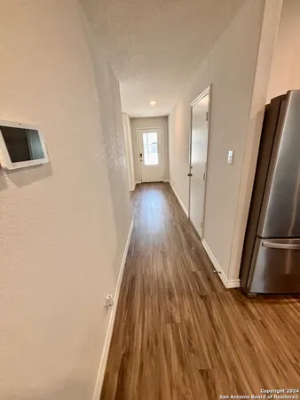a view of a hallway with wooden floor and staircase