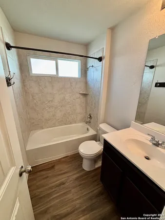 a bathroom with a sink a toilet a mirror and shower