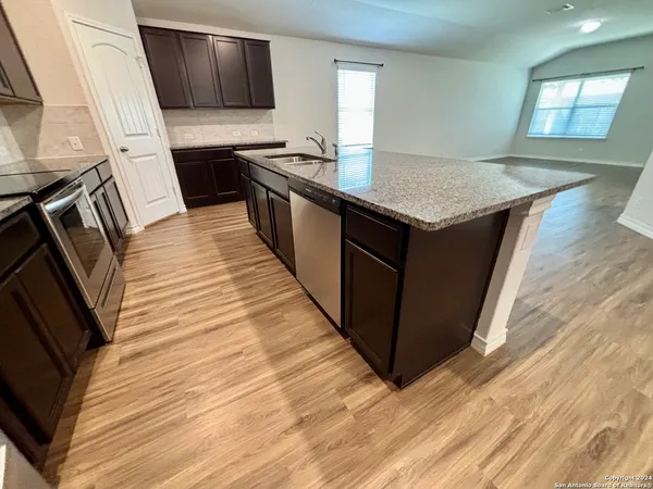 a kitchen with stainless steel appliances granite countertop a stove a sink and a refrigerator