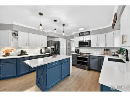 a large kitchen with stainless steel appliances lots of counter space a sink and a refrigerator
