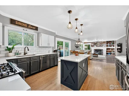 a kitchen with kitchen island granite countertop a sink cabinets and window