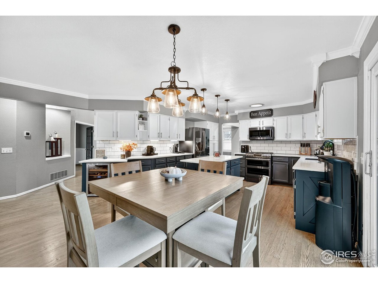 9910 Ashleigh Way Highlands Ranch, CO 80126 - Photo 15 of 45 a open kitchen with stainless steel appliances kitchen island granite countertop a stove top oven a dining table and chairs with wooden floor