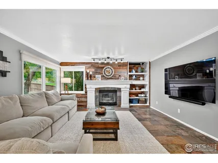 a living room with furniture a fireplace and a large window
