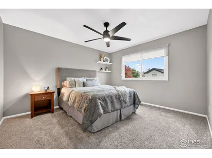a bedroom with a bed and a ceiling fan