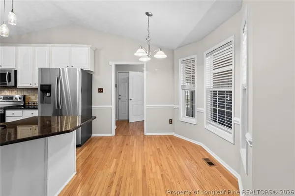 a view of a kitchen with wooden floor and a refrigerator