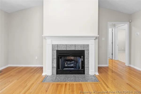 a living room with a fireplace and wooden floor