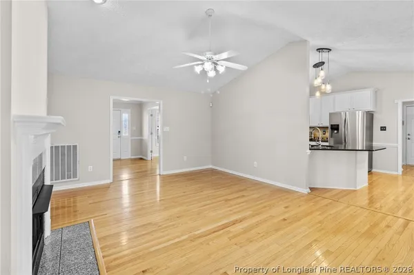 a view of a kitchen with wooden floor and a kitchen space with a sink