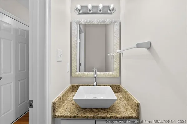 a bathroom with a granite countertop sink and a mirror
