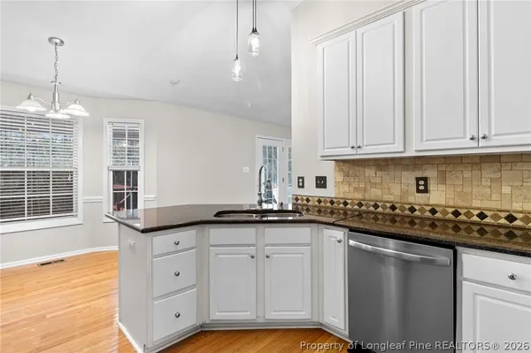 a kitchen with granite countertop a sink and cabinets