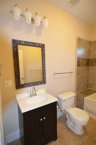 a bathroom with a sink vanity mirror and toilet