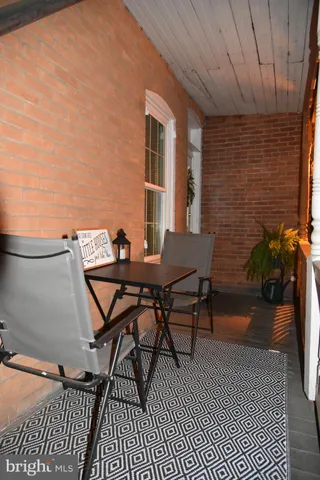 a patio with table and chairs and potted plants