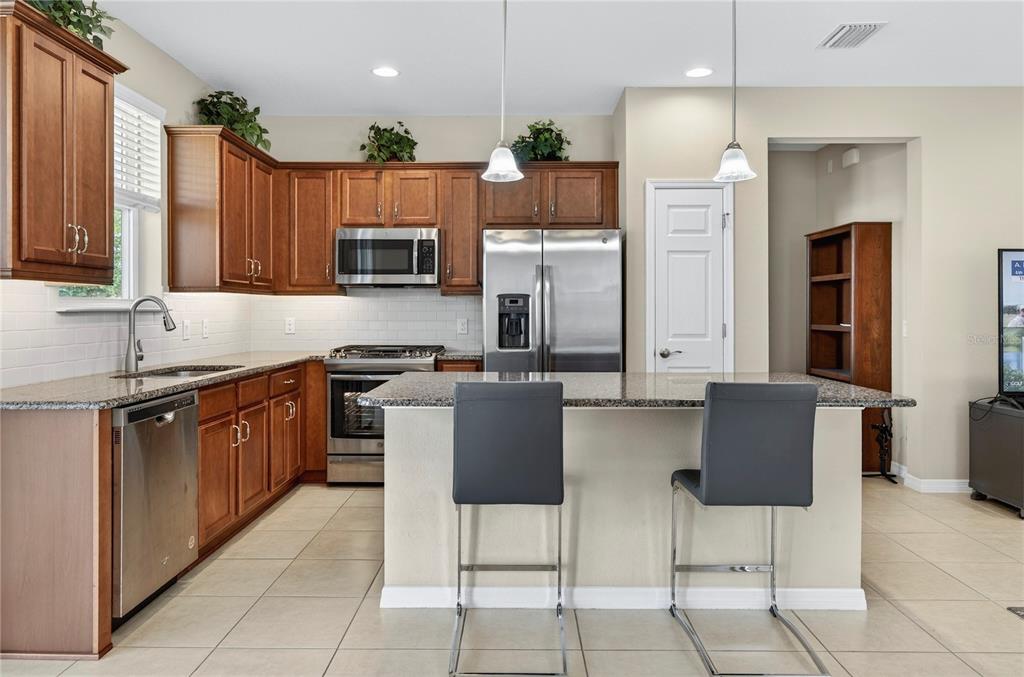 3947 Northwest 46th Ter. Ocala, FL 34482 - Photo 12 of 75 a kitchen with stainless steel appliances granite countertop a stove top oven a refrigerator a sink and a microwave