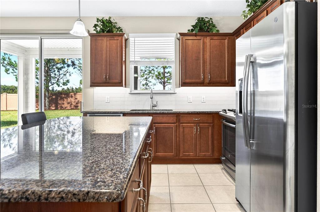 3947 Northwest 46th Ter. Ocala, FL 34482 - Photo 14 of 75 a kitchen with kitchen island granite countertop a refrigerator and a sink