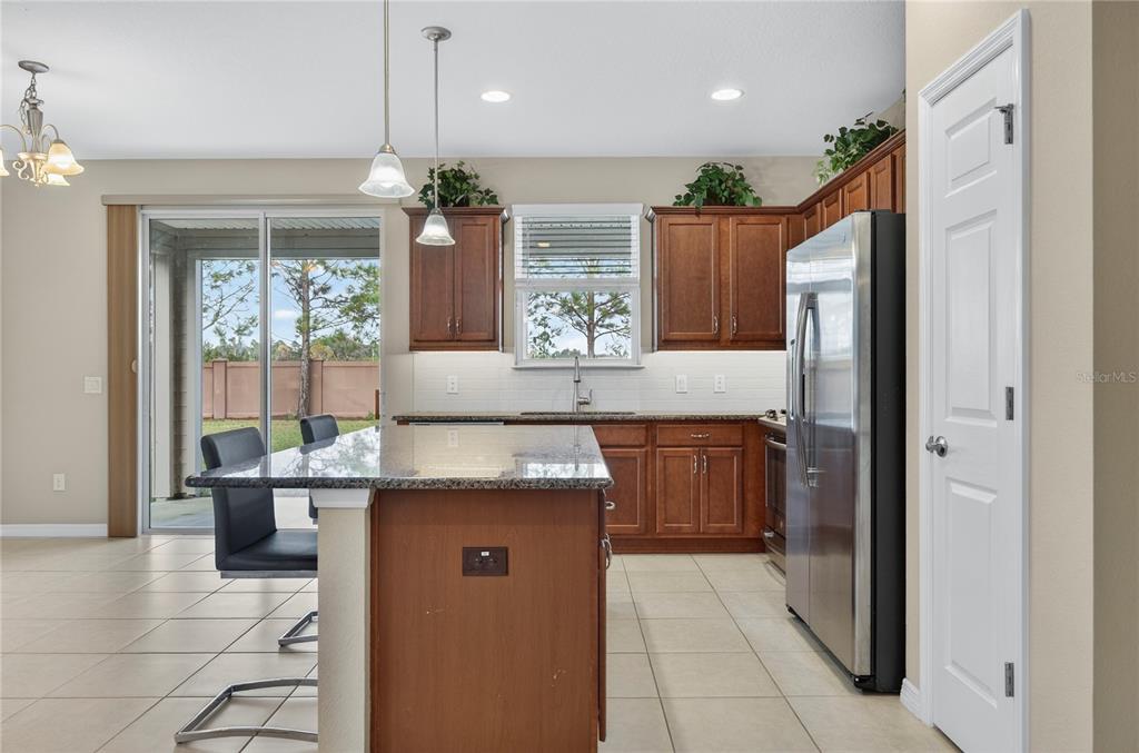 3947 Northwest 46th Ter. Ocala, FL 34482 - Photo 15 of 75 a kitchen with kitchen island granite countertop a refrigerator and microwave