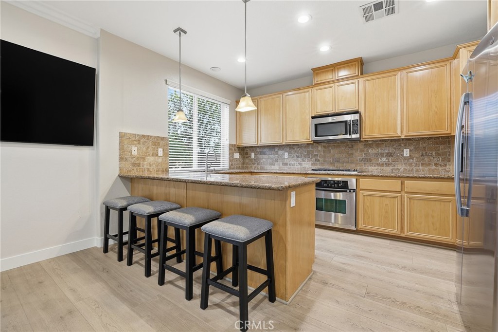 8220 Chamberlain Reseda, CA 91335 - Photo 17 of 46 a kitchen with kitchen island granite countertop a sink counter and chairs