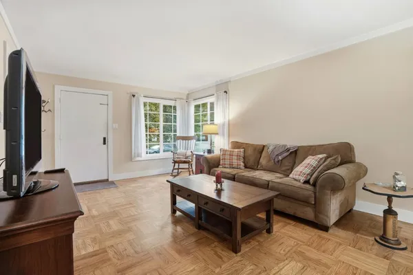 a living room with furniture a flat screen tv and a window