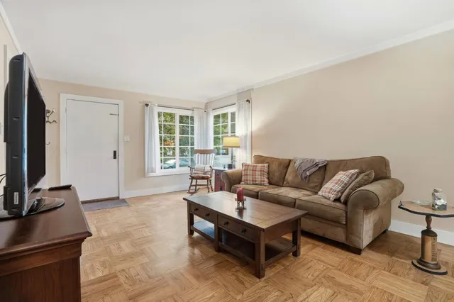 a living room with furniture a flat screen tv and a window