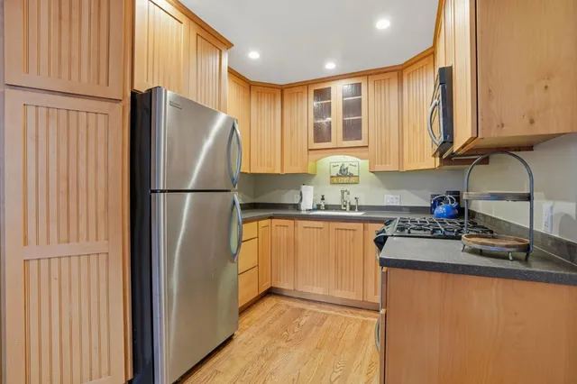 a kitchen with stainless steel appliances granite countertop a refrigerator a sink and dishwasher