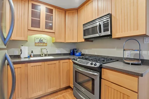 a kitchen with stainless steel appliances granite countertop a stove microwave and sink
