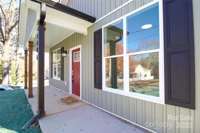a view of a porch with a floor to ceiling window and wooden floor