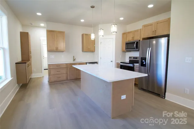 a kitchen with stainless steel appliances a refrigerator and a sink