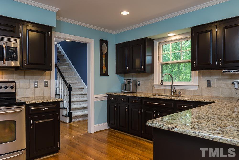 717 Bennington Drive Raleigh, NC 27615 - Photo 6 of 25 a kitchen with a sink stove and cabinets