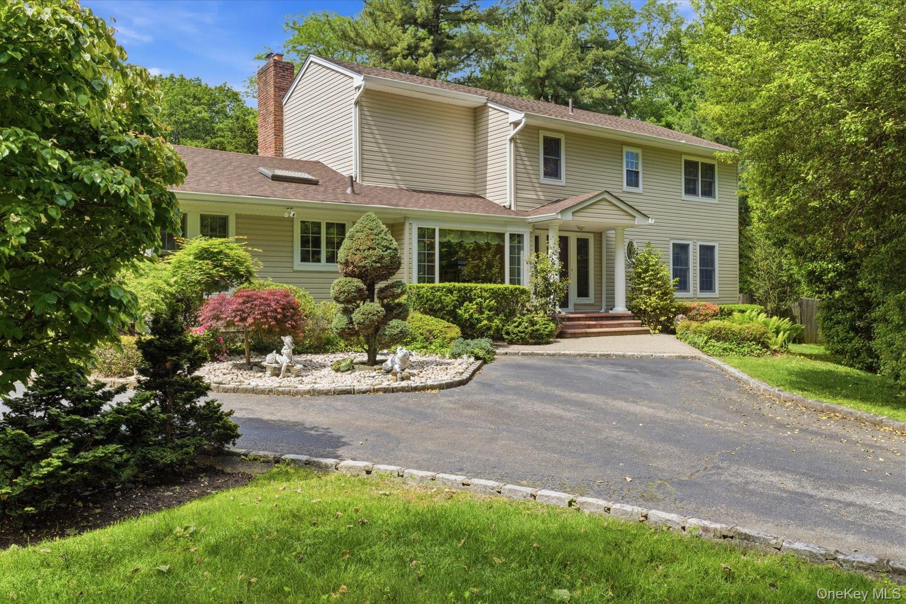 a front view of a house with yard and green space
