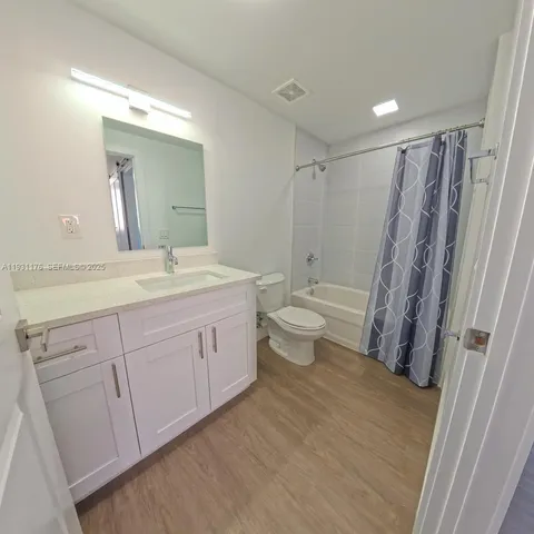 a spacious bathroom with a double vanity sink toilet mirror and shower