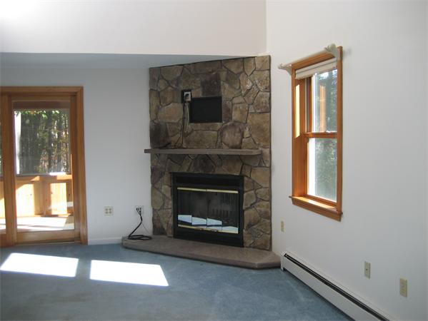 18 A Riverview Road, Unit A Sterling, MA 01564 - Photo 9 of 21 a living room with a fireplace and windows