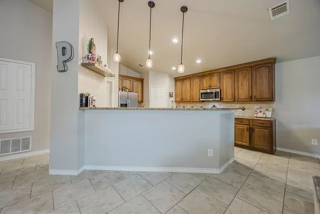 a kitchen with stainless steel appliances granite countertop a refrigerator a sink and a stove