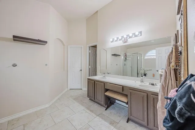 a spacious bathroom with a double vanity sink and a mirror