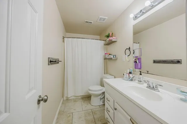 a bathroom with a double vanity sink toilet mirror and shower