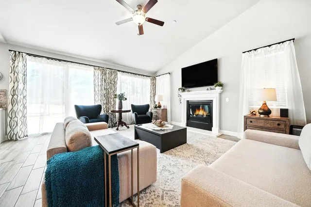 a living room with furniture a fireplace and a flat screen tv