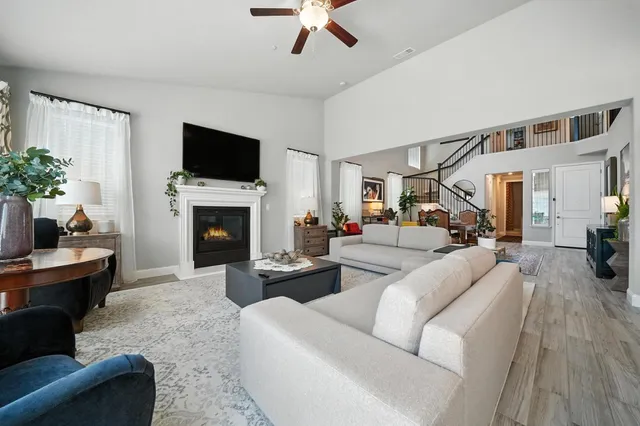 a living room with furniture kitchen view and a chandelier