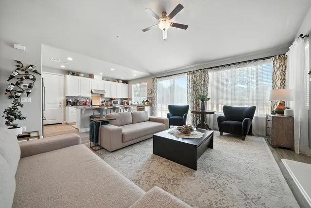 a kitchen with stainless steel appliances granite countertop a stove top oven a sink a refrigerator and white cabinets