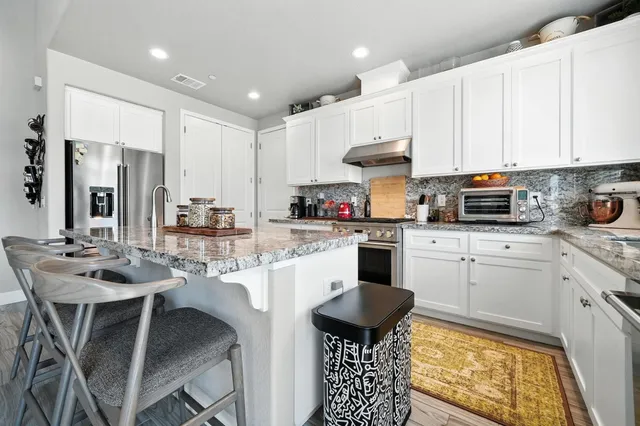 a kitchen with stainless steel appliances granite countertop a stove and a microwave