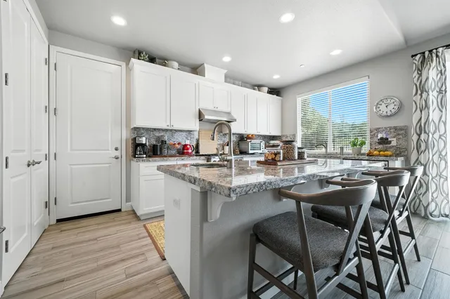 a kitchen with stainless steel appliances granite countertop a sink stove and cabinets