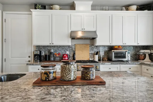 a kitchen with stainless steel appliances granite countertop a stove sink and cabinets