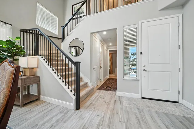 a view of a hallway with wooden floor and stairs