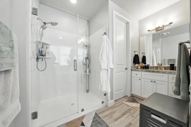 a bathroom with a granite countertop sink a large mirror and a bathtub