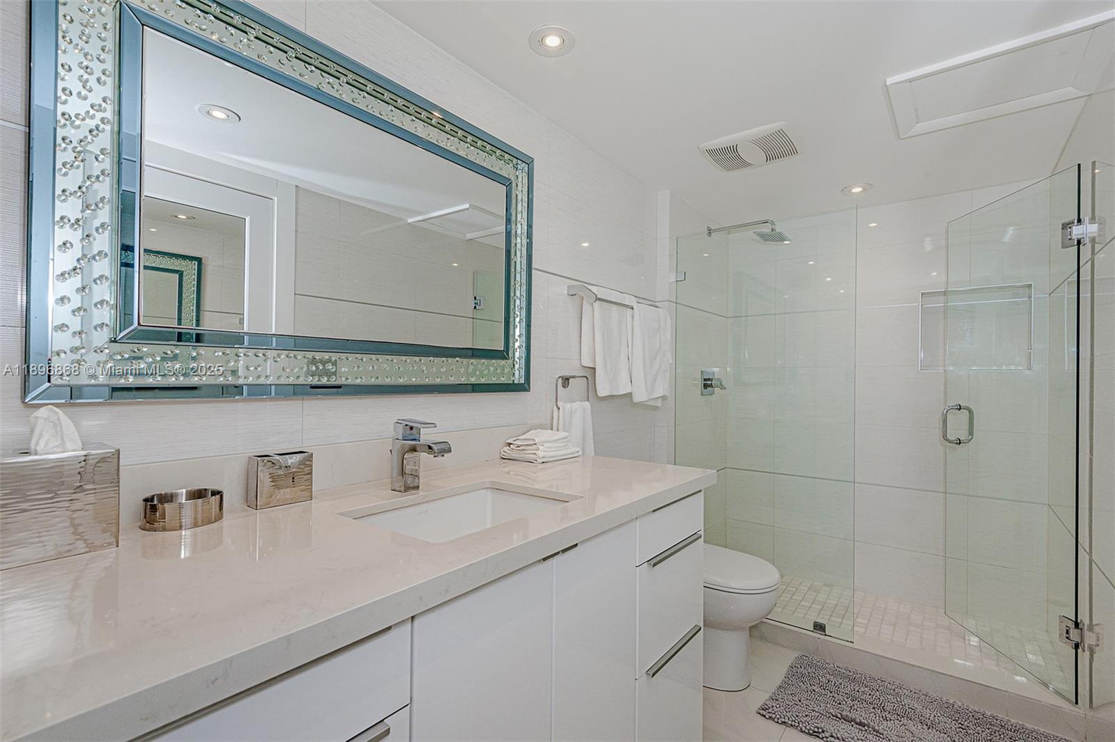 2301 Collins Avenue, Unit 1211 Miami Beach, FL 33139 - Photo 17 of 24 a bathroom with a toilet a sink a mirror and shower