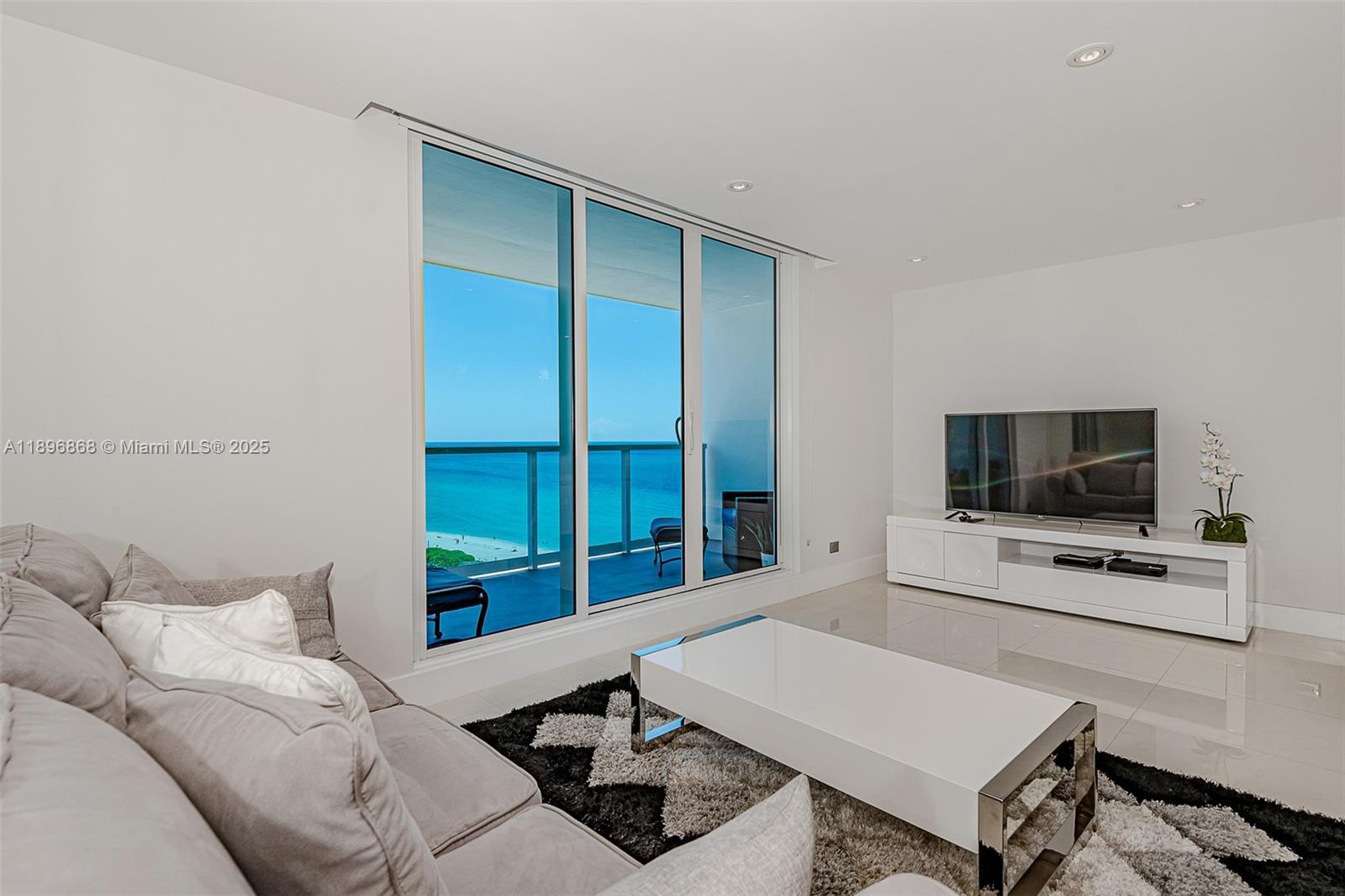 2301 Collins Avenue, Unit 1211 Miami Beach, FL 33139 - Photo 4 of 24 a living room with furniture and a flat screen tv