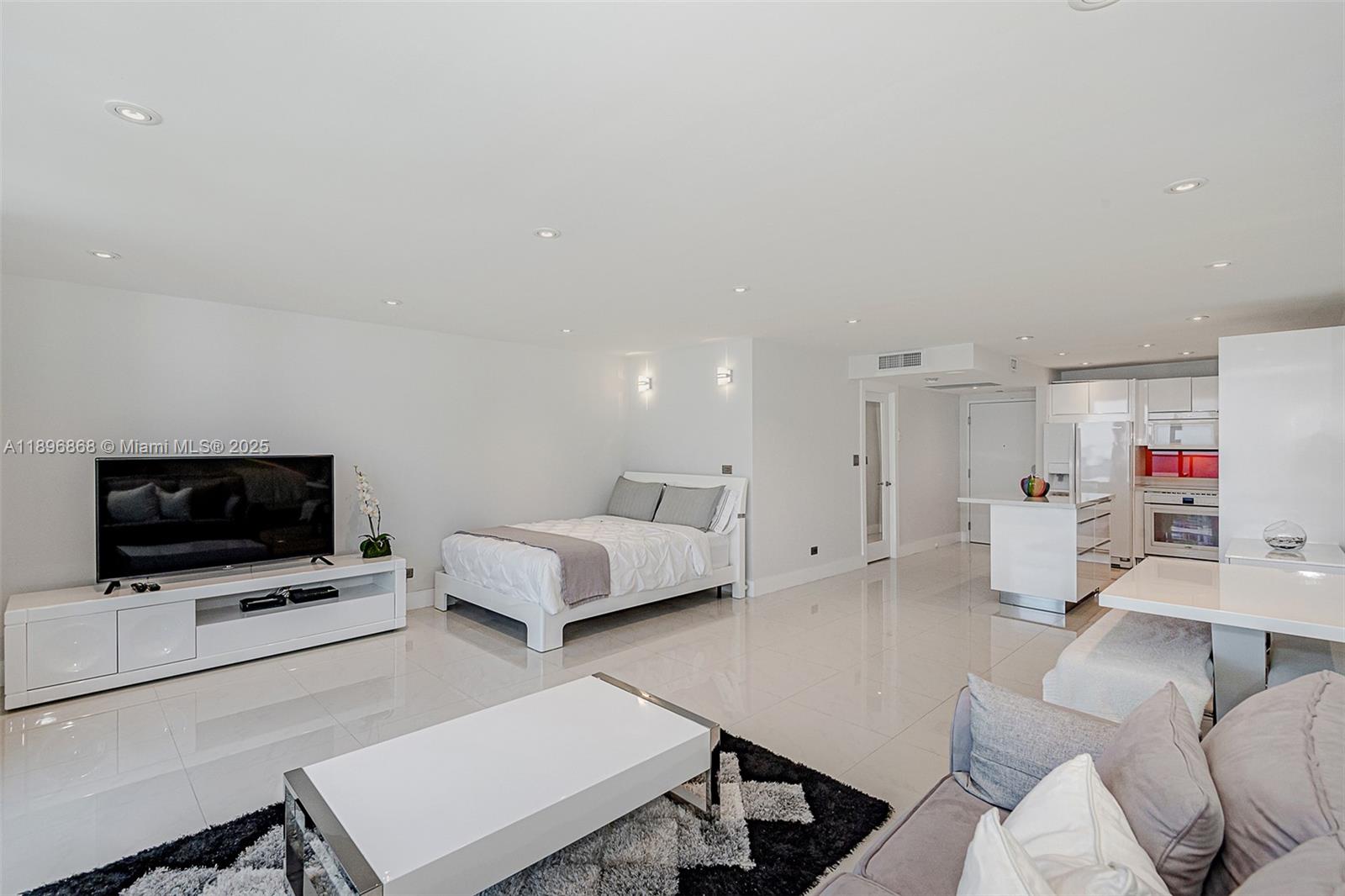 2301 Collins Avenue, Unit 1211 Miami Beach, FL 33139 - Photo 6 of 24 a living room with furniture and a flat screen tv