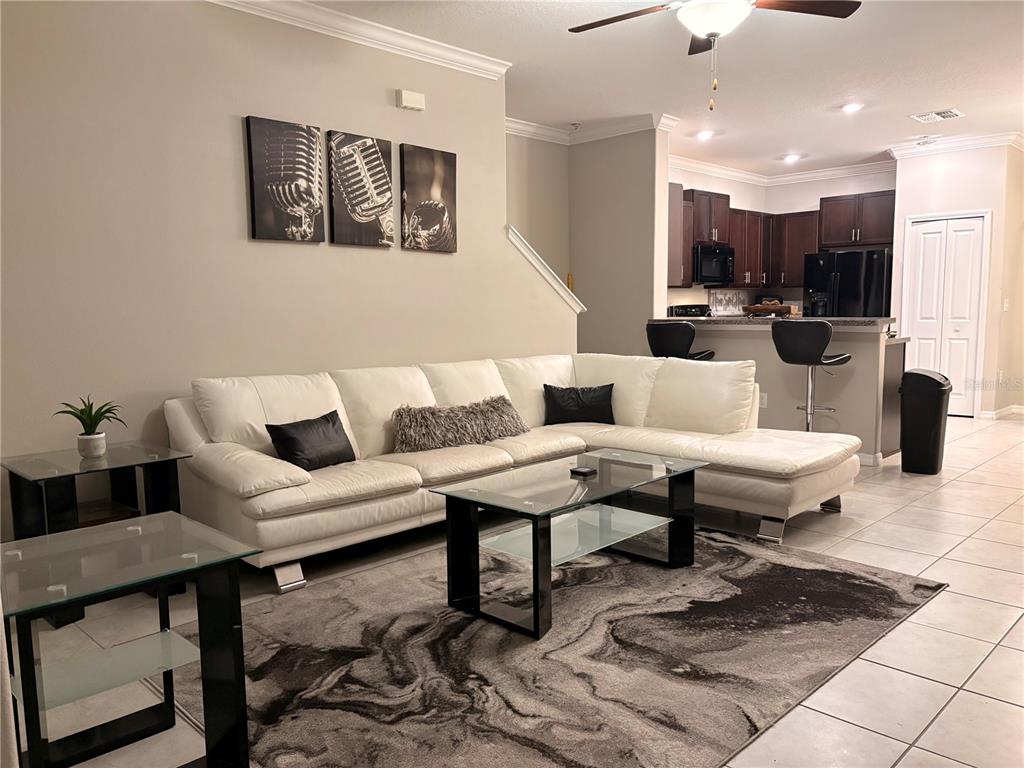 11768 Dumaine Valley Road Riverview, FL 33579 - Photo 2 of 6 a living room with couches a table and kitchen view with wooden floor